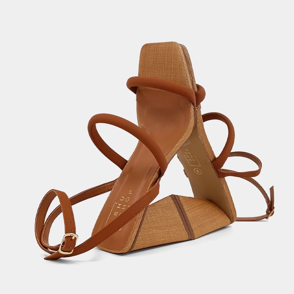 Crafted from luxurious faux leather with a stunning woven texture, supported by an eye-catching pyramid-shaped heel, and secured with an elegant ankle strap, EVANGELINE is the ultimate high-heel sandal to elevate any outfit, from flowing dresses to casual denim.