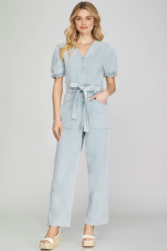 Get ready to soar in the Blue Skies Jumpsuit! Combining comfort and style, this jumpsuit features a puffed sleeve, v-neck, and waist tie for a flattering fit. With a convenient zip-up design and practical side pockets, you'll never want to take off this woven jumpsuit. Perfect for any occasion.