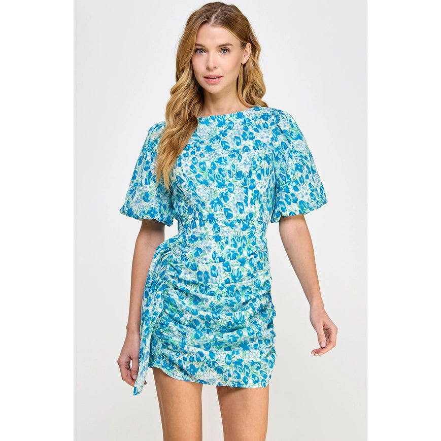 Be the belle of the garden party in our Floral Galore Dress! This flirty mini dress boasts ruched short puff sleeves and a shirred mini skirt, all adorned with a whimsical floral print. Made of lightweight cotton voile and complete with lining and hidden zipper closure, it's the perfect choice for a playful and stylish look.