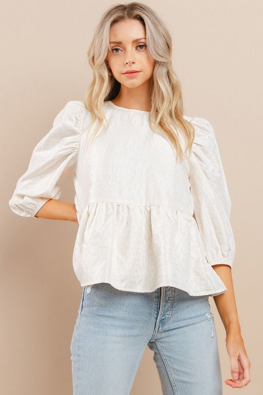 Elevate your wardrobe with our Southern Belle Top. This textured top boasts puff half sleeves that add a touch of elegance. The ruffle hem and back buttoned keyhole elevate the look even further, making it perfect for any occasion. Make a statement with this must-have piece!