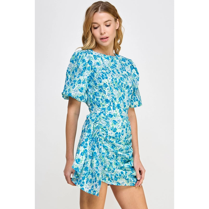 Be the belle of the garden party in our Floral Galore Dress! This flirty mini dress boasts ruched short puff sleeves and a shirred mini skirt, all adorned with a whimsical floral print. Made of lightweight cotton voile and complete with lining and hidden zipper closure, it's the perfect choice for a playful and stylish look.