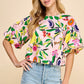 Introducing the Resort Cutie Top: a vibrant and playful addition to your wardrobe. This abstract printed top boasts short balloon sleeves and a flattering dropped shoulder design, perfect for any occasion. With a back keyhole and button closures, it's effortlessly stylish and easy to wear. Order yours today!