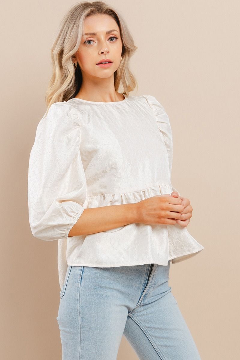 Elevate your wardrobe with our Southern Belle Top. This textured top boasts puff half sleeves that add a touch of elegance. The ruffle hem and back buttoned keyhole elevate the look even further, making it perfect for any occasion. Make a statement with this must-have piece!