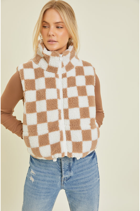 This season, stay cozy and stylish with this sherpa checkered vest! Featuring a fashionable checkered print and ultra-soft sherpa - you won't want to take it off! Perfect for family dinners, date night, or just lounging around the house. Un-vest-itively awesome!