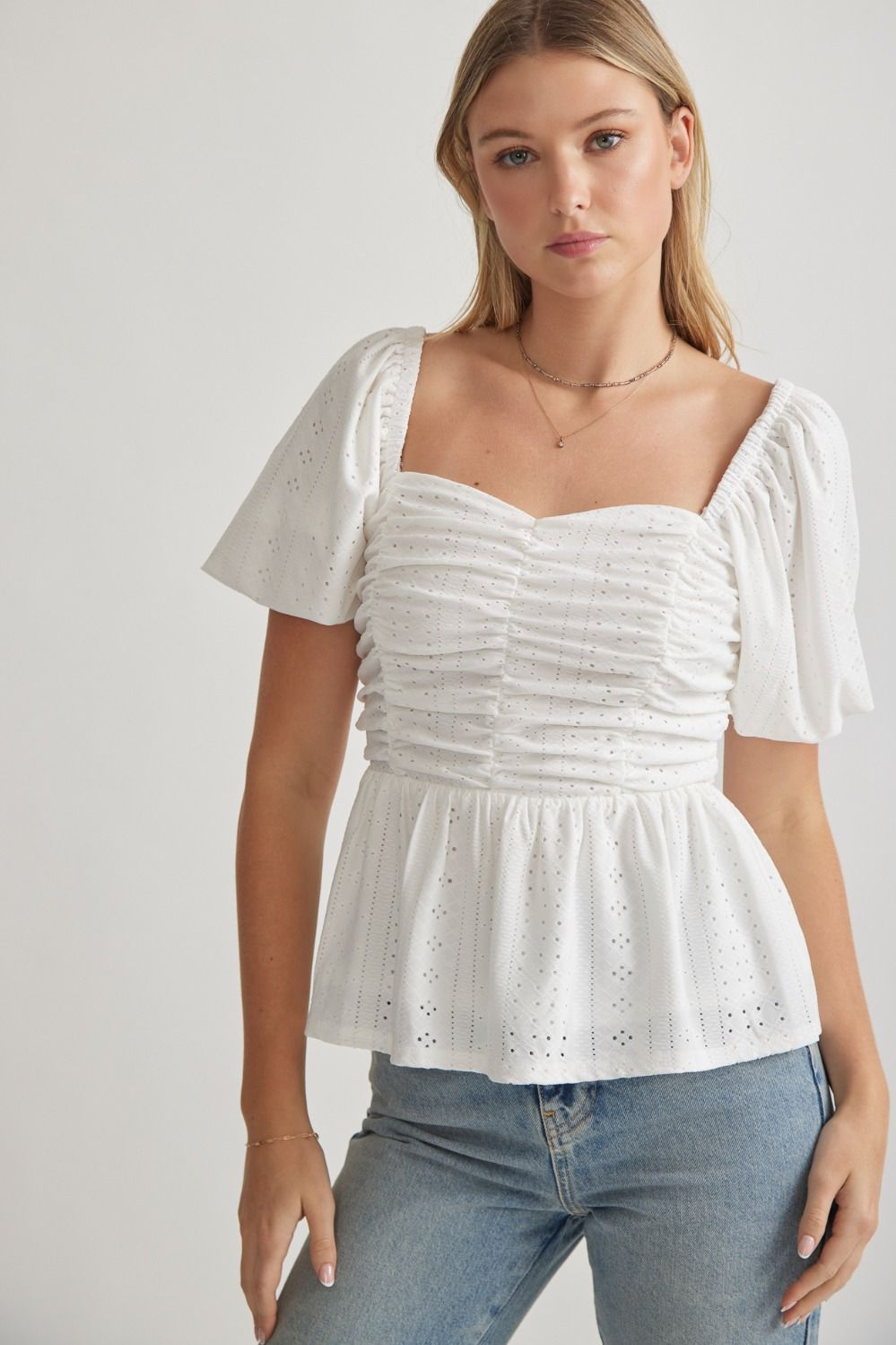 Elevate your wardrobe with our Springtime Sip Top! This eyelet sweetheart neckline top features delicate puff sleeves and ruching at the front, giving it a romantic and elegant look. The smocked back and lining provide a comfortable, flattering fit. Made with high-quality woven fabric, this top is non-sheer and perfect for any occasion. Transform your outfit with this must-have piece!